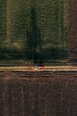 Aerial view of agricultural tractor with tiller attached driving on dirt road