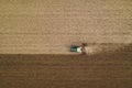 Aerial view of agricultural tractor tilling and harrowing ploughed field, directly above drone pov Royalty Free Stock Photo