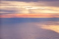 Aerial view from airplane of bright colorful pink red yellow orange sun beams in clouds on light blue sky at sunset sunrise. Royalty Free Stock Photo