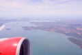 Aerial view of airplane flying above shade clouds and sky. Airplane wing fly over tropical island. View from the plane Royalty Free Stock Photo