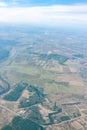 Aerial view from airplane window above green ground. View from the airplane window with beautiful clouds at sunrise Royalty Free Stock Photo