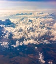 Aerial view from airplane window above green ground. View from the airplane window with beautiful clouds at sunrise Royalty Free Stock Photo