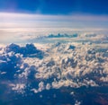 Aerial view from airplane window above green ground. View from the airplane window with beautiful clouds at sunrise Royalty Free Stock Photo