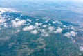 Aerial view from airplane window above grenn ground. View from the airplane window with beautiful clouds at sunrise Royalty Free Stock Photo