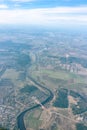 Aerial view from airplane window above grenn ground. View from the airplane window with beautiful clouds at sunrise Royalty Free Stock Photo