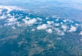 Aerial view from airplane window above grenn ground. View from the airplane window with beautiful clouds at sunrise Royalty Free Stock Photo