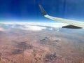 Aerial view from the airplane window with blue horizon.