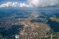 Aerial view from airplane window at high altitude of distant city covered with puffy cumulus clouds forming before rainstorm Royalty Free Stock Photo