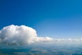 Aerial view from airplane window at high altitude of earth covered with white puffy cumulus clouds Royalty Free Stock Photo