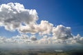 Aerial view from airplane window at high altitude of earth covered with white puffy cumulus clouds Royalty Free Stock Photo