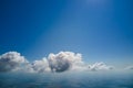 Aerial view from airplane window at high altitude of earth covered with white puffy cumulus clouds Royalty Free Stock Photo