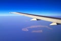 Aerial view of airplane wing and Santorini island