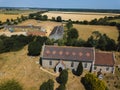 An aerial view of All Saints church in Sutton with a farm and farm fields in the background Royalty Free Stock Photo