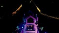 Aerial view of Allama Iqbal Road roundabout in night with colorful lights, buildings and traffic