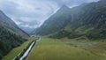 Aerial view on alpine valley with storm clouds approaching in the background, Austrian Alps Royalty Free Stock Photo