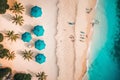 Aerial view of amazing beach with umbrellas and lounge chairs beds close to turquoise sea. Top view of summer beach landscape,