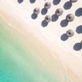 Aerial view of amazing tropical white sandy beach with palm leaves umbrellas and turquoise sea. Royalty Free Stock Photo