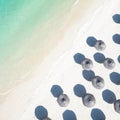 Aerial view of amazing tropical white sandy beach with palm leaves umbrellas and turquoise sea. Royalty Free Stock Photo