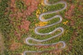 Aerial view of an amazing winding curved road through the mountains in autumn fall colors landscape, motorway in Romania Royalty Free Stock Photo