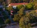 Aerial View of American College Campus with Red-Roofed Building and Flags at Sunrise Royalty Free Stock Photo