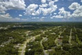 Aerial view of american small town in Florida with private homes between green palm trees and suburban streets in quiet