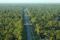 Aerial view of american small town in Florida with private homes between green palm trees and suburban streets in quiet