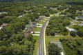 Aerial view of american small town in Florida with private homes between green palm trees and suburban streets in quiet