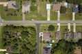 Aerial view of american small town in Florida with private homes between green palm trees and suburban streets in quiet