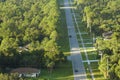 Aerial view of american small town in Florida with private homes between green palm trees and suburban streets in quiet