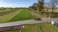 Aerial View of an Amish Pick Up Horse and Buggy Traveling Down a Rural Country Road, Thru Farm Fields on a Sunny Autumn Royalty Free Stock Photo