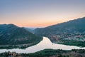 Aerial view of the ancient small illuminated town Mtskheta and view of the merger of two rivers at sunset