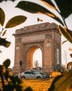 Aerial view of Arch of Triumph under blue bright sky in Bucharest