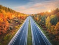 Aerial view of asphalt road in beautiful autumn forest at sunset Royalty Free Stock Photo