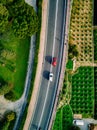 Aerial view of the asphalt road with cars going among the agricultural fields in Italy