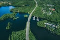 Aerial view of asphalt road with cars over blue lake and green woods in Finland Royalty Free Stock Photo