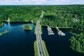 Aerial view of asphalt road with cars over blue lake and green woods in Finland Royalty Free Stock Photo