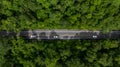 Aerial view asphalt road in the middle fores with car, Asphalt road through the mountain and green forest