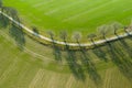 Aerial view on a asphalt road separated two cultivated fields. Top view on a motorway between farmers lands. Royalty Free Stock Photo