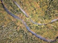 Aerial view of the autumn forest and small stream. Way along the river in the mountains covered with green and colorful forest Royalty Free Stock Photo