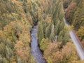 Aerial view of the autumn forest and small stream. Way along the river in the mountains covered with green and colorful forest Royalty Free Stock Photo