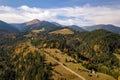 Aerial view of autumn mountain landscape with evergreen pine trees and yellow fall forest with magestic mountains in distance Royalty Free Stock Photo