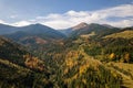 Aerial view of autumn mountain landscape with evergreen pine trees and yellow fall forest with magestic mountains in distance Royalty Free Stock Photo