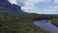 Aerial view of the Auyantepuy mesa, a river, and the Amazon rainforest, Canaima National park, Venezuela, zoom out