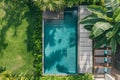 Aerial view of backyard of modern villa with rectangular swimming pool,with clear water,with sun loungers placed around pool, Royalty Free Stock Photo