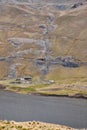 Aerial view of a barn near a river and rocky hill Royalty Free Stock Photo