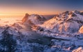 Aerial view of snowy mountains, blue sea and orange sky at sunset Royalty Free Stock Photo