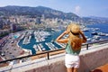 Aerial view of beautiful girl in Monte-Carlo looking cityscape with skyscrapers and harbor in Monaco City-State