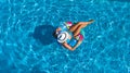 Aerial view of beautiful girl in swimming pool from above, swim on inflatable ring donut and has fun in water