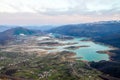 Aerial view of beautiful green lake and islands surrounded by mountains. Autumn landscape at evening. Large artificially formed la