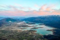 Aerial view of beautiful green lake and islands surrounded by mountains. Autumn landscape at evening. Large artificially formed la